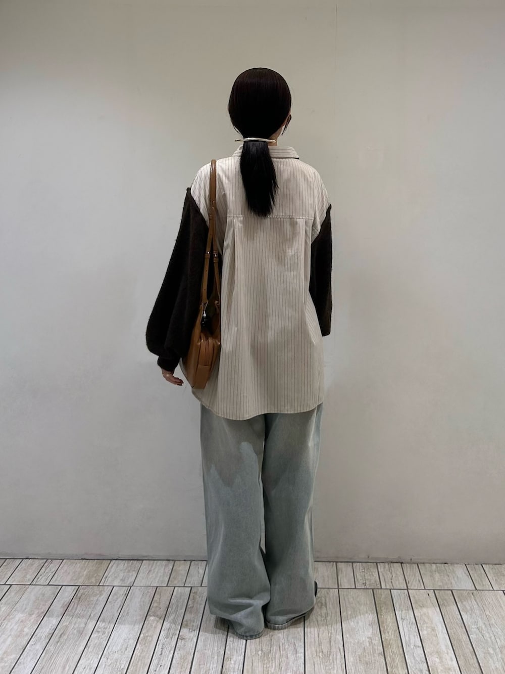 ベージュ系のシャツ/ブラウス、イエロー系のショルダーバッグ、ブルー系のデニムパンツを着用したレディースの秋コーディネートの4枚目の写真