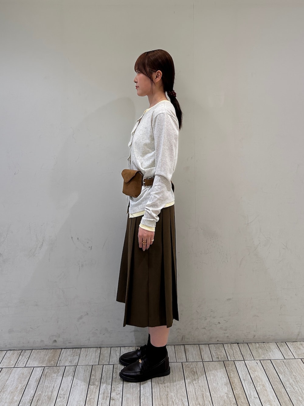 ベージュ系のTシャツ/カットソー、イエロー系のボディバッグ/ウエストポーチ、ブラウン系のスカートを着用したレディースの秋コーディネートの2枚目の写真