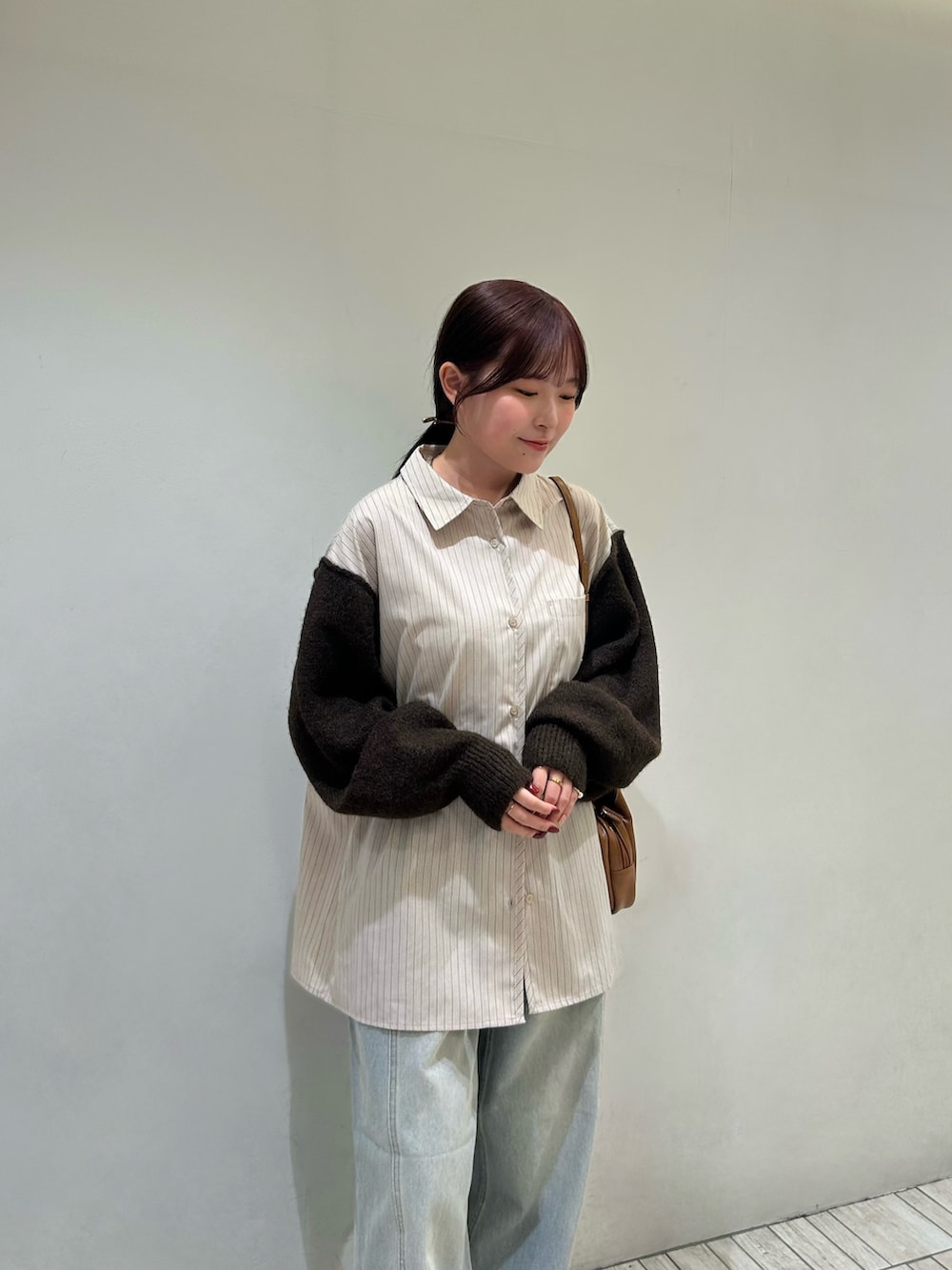 ベージュ系のシャツ/ブラウス、イエロー系のショルダーバッグ、ブルー系のデニムパンツを着用したレディースの秋コーディネートの5枚目の写真