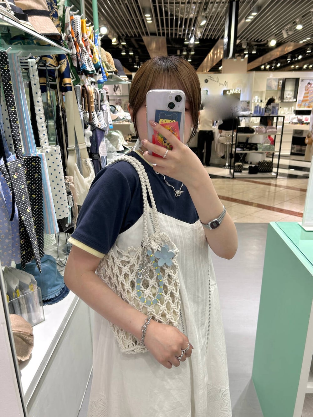 ホワイト系のハンドバッグ、シルバー系のリング、ホワイト系のバレッタ/ヘアクリップを着用したレディースの夏コーディネートの4枚目の写真