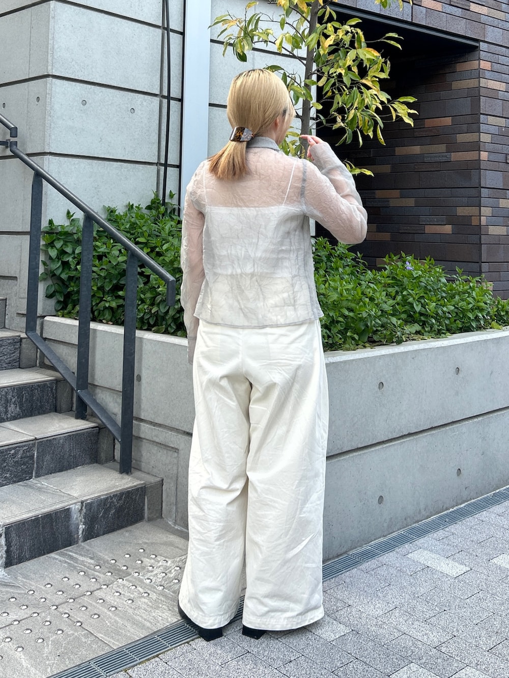 グレー系のシャツ/ブラウス、ホワイト系のその他パンツ、ブラック系のパンプスを着用したレディースの春コーディネートの4枚目の写真