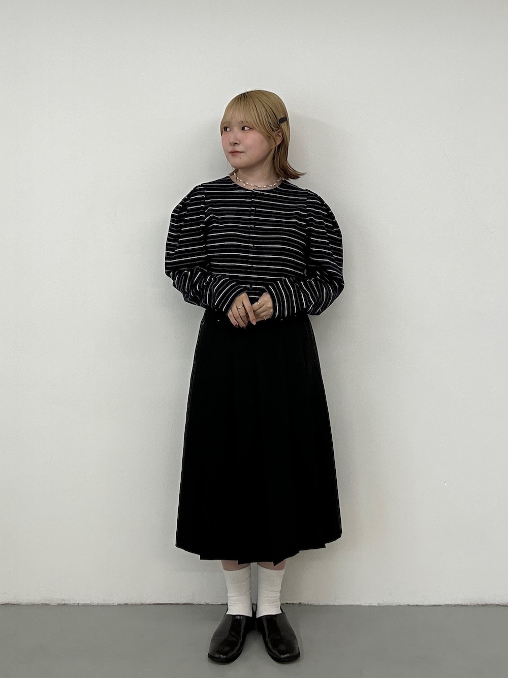 グレー系のその他シューズ、グレー系のスカート、ブルー系のカーディガン/ボレロを着用したレディースの冬コーディネートの3枚目の写真