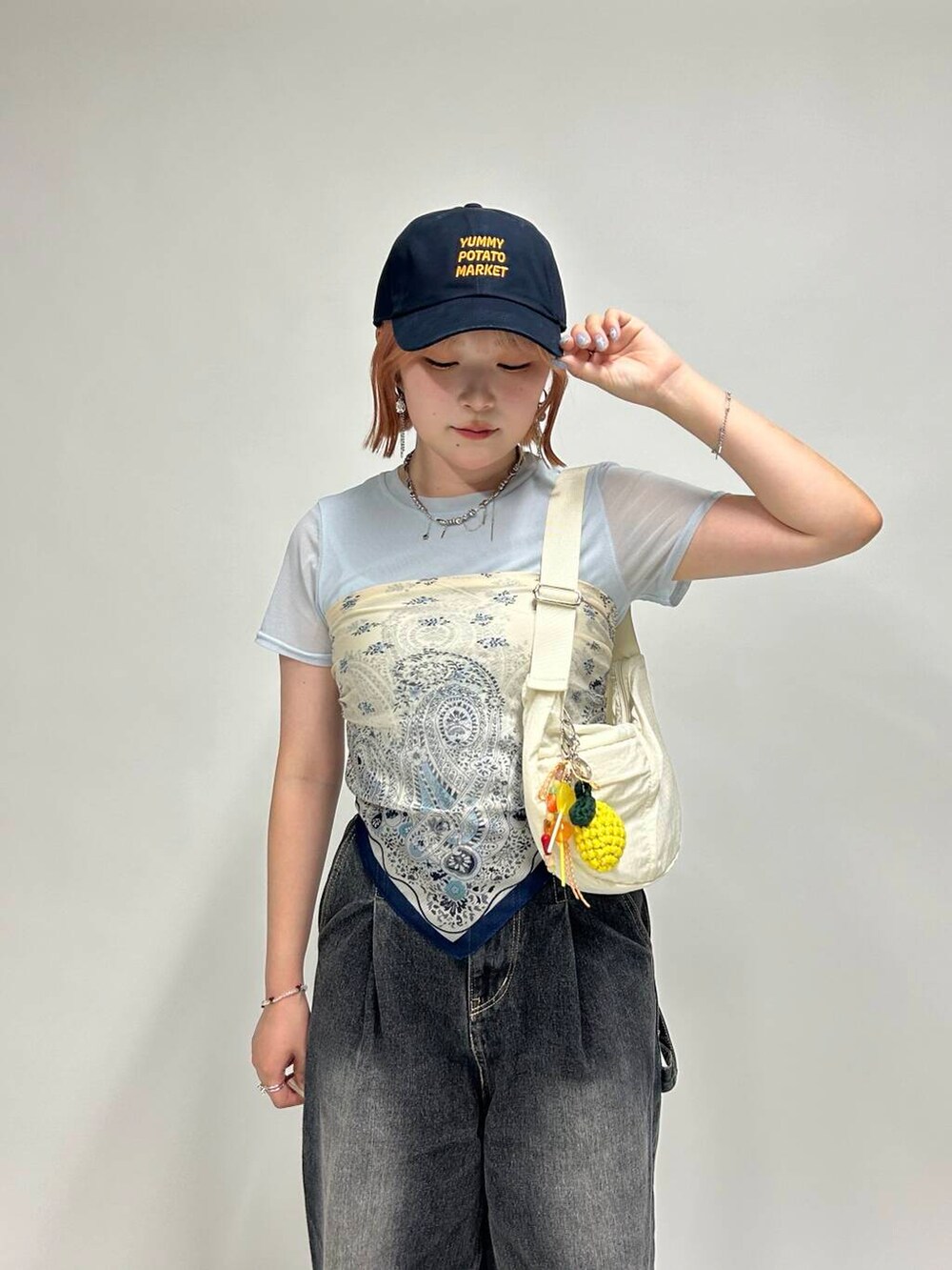 ホワイト系のショルダーバッグ、シルバー系のネックレス、シルバー系のイヤリングを着用したレディースの夏コーディネートの4枚目の写真