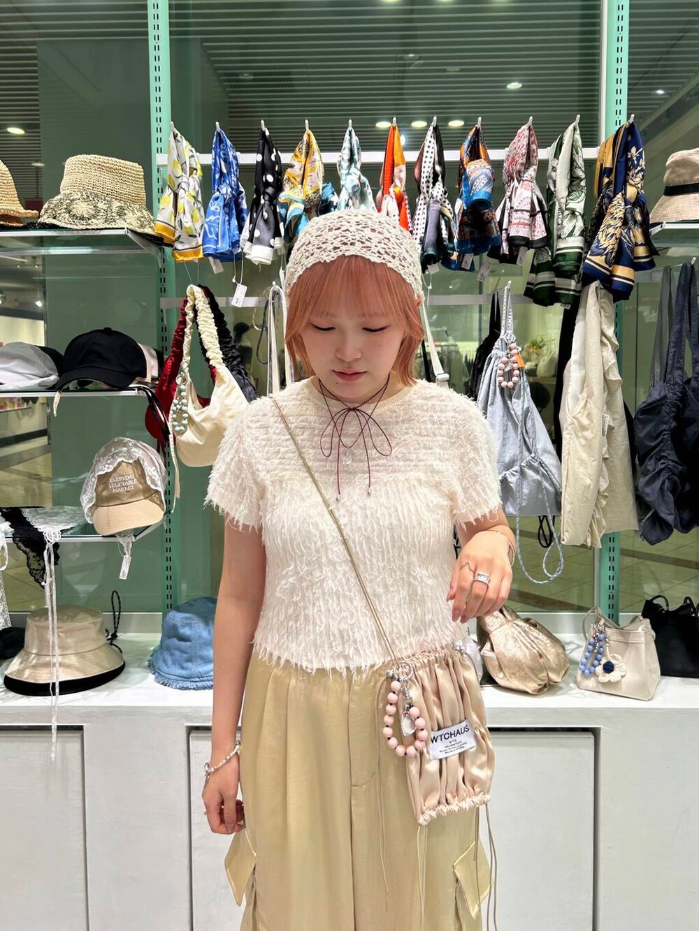 ベージュ系のその他パンツ、ホワイト系のブレスレット、レッド系のネックレスを着用したレディースの夏コーディネートの6枚目の写真