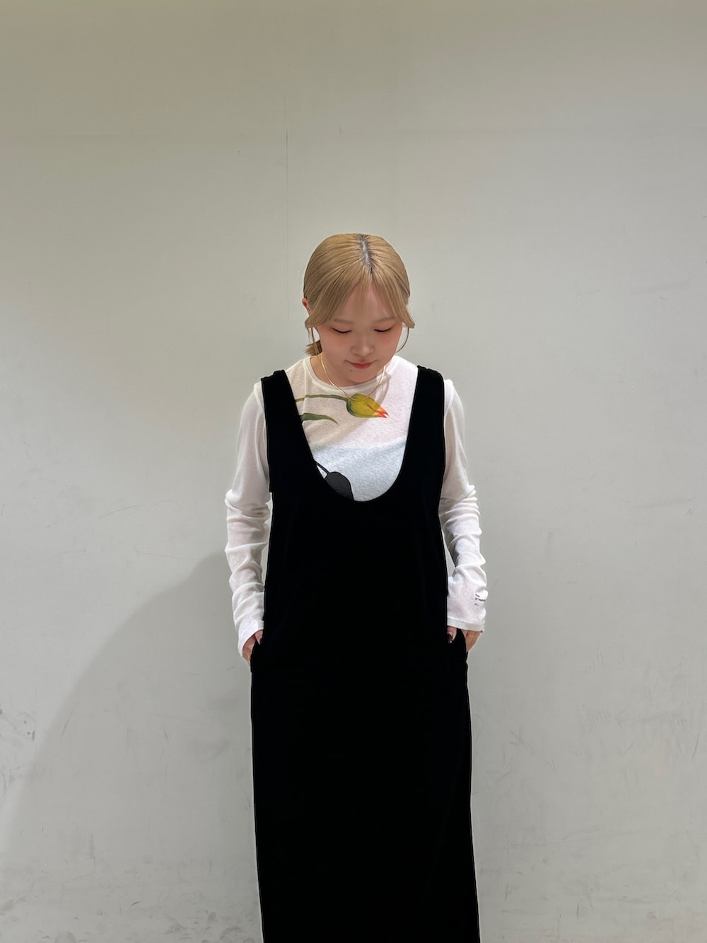 ブラック系のワンピース、ホワイト系のTシャツ/カットソー、グリーン系のパンプスを着用したレディースの春コーディネートの5枚目の写真