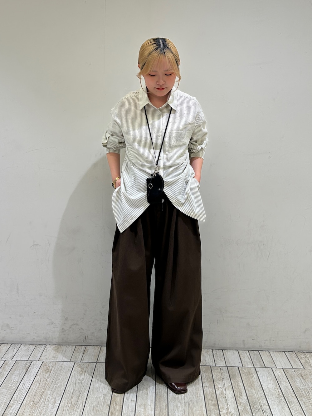 ホワイト系のシャツ/ブラウス、ブラウン系のその他パンツ、ブラック系のその他雑貨を着用したレディースの春コーディネートの2枚目の写真