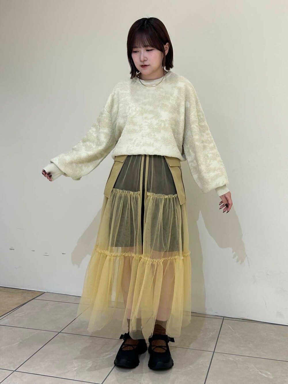 ブラック系のスニーカー、ベージュ系のスカート、ブラウン系のその他パンツを着用したレディースの夏コーディネートの3枚目の写真