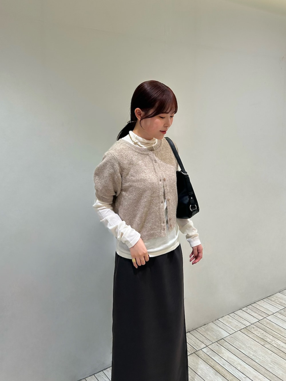 ベージュ系のカーディガン/ボレロ、ブラック系のショルダーバッグ、ブラウン系のスカートを着用したレディースの秋コーディネートの5枚目の写真