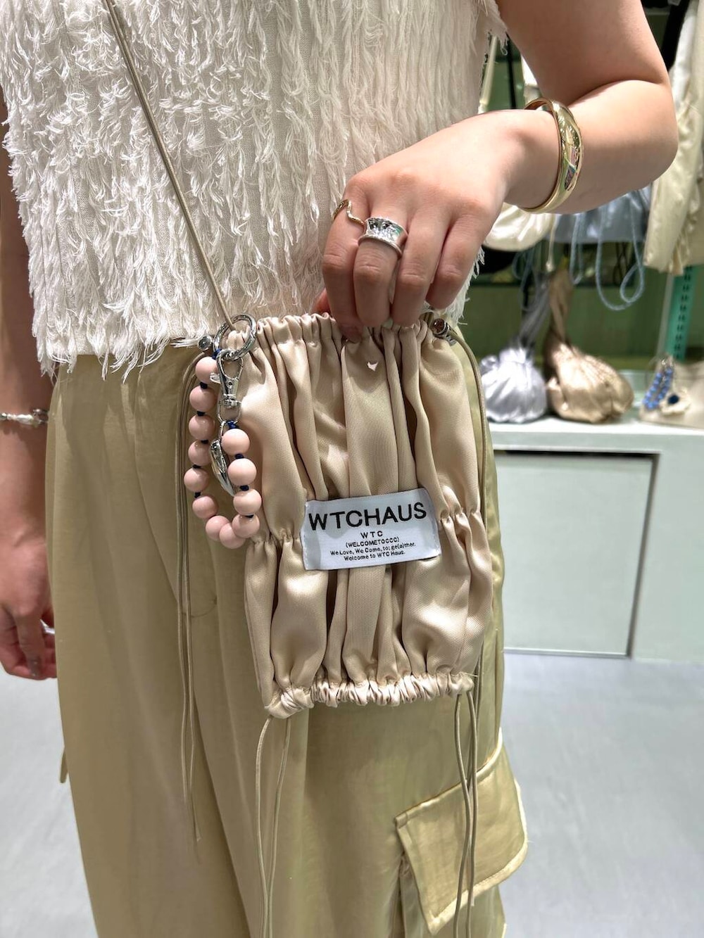 ベージュ系のその他パンツ、ホワイト系のブレスレット、レッド系のネックレスを着用したレディースの夏コーディネートの5枚目の写真