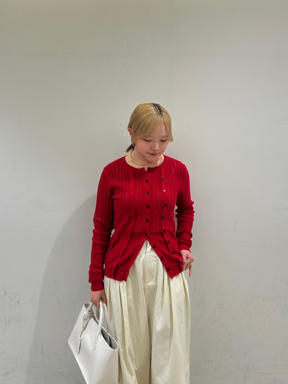 ホワイト系のその他パンツ、ホワイト系のハンドバッグ、レッド系のニット/セーターを着用したレディースの春コーディネートの6枚目の写真