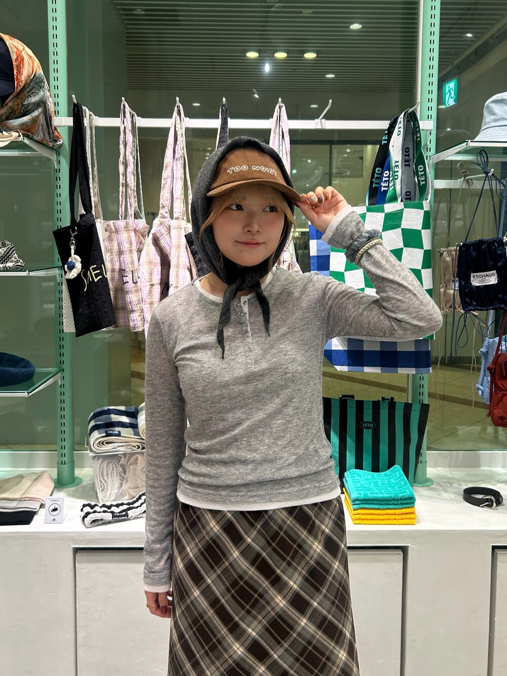 ブラック系のスニーカー、ブラウン系のスカート、ブラック系のショルダーバッグを着用したレディースの秋コーディネートの3枚目の写真