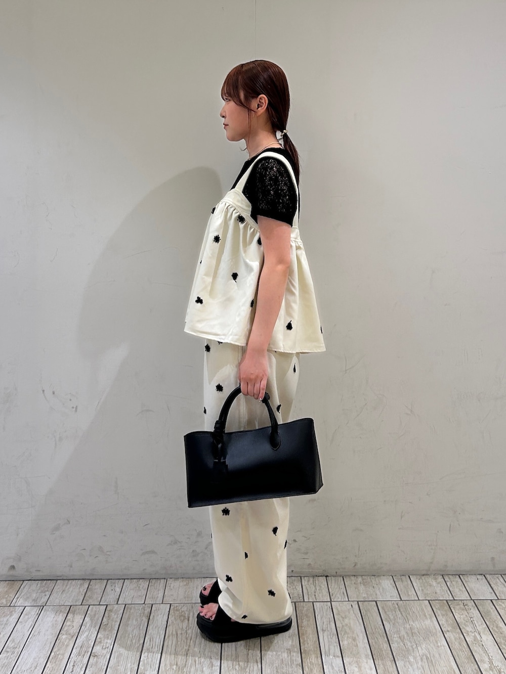 ホワイト系のシャツ/ブラウス、ホワイト系のその他パンツ、ブラック系のハンドバッグを着用したレディースの夏コーディネートの4枚目の写真