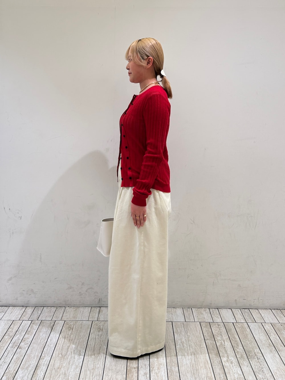 ホワイト系のその他パンツ、ホワイト系のハンドバッグ、レッド系のニット/セーターを着用したレディースの春コーディネートの3枚目の写真