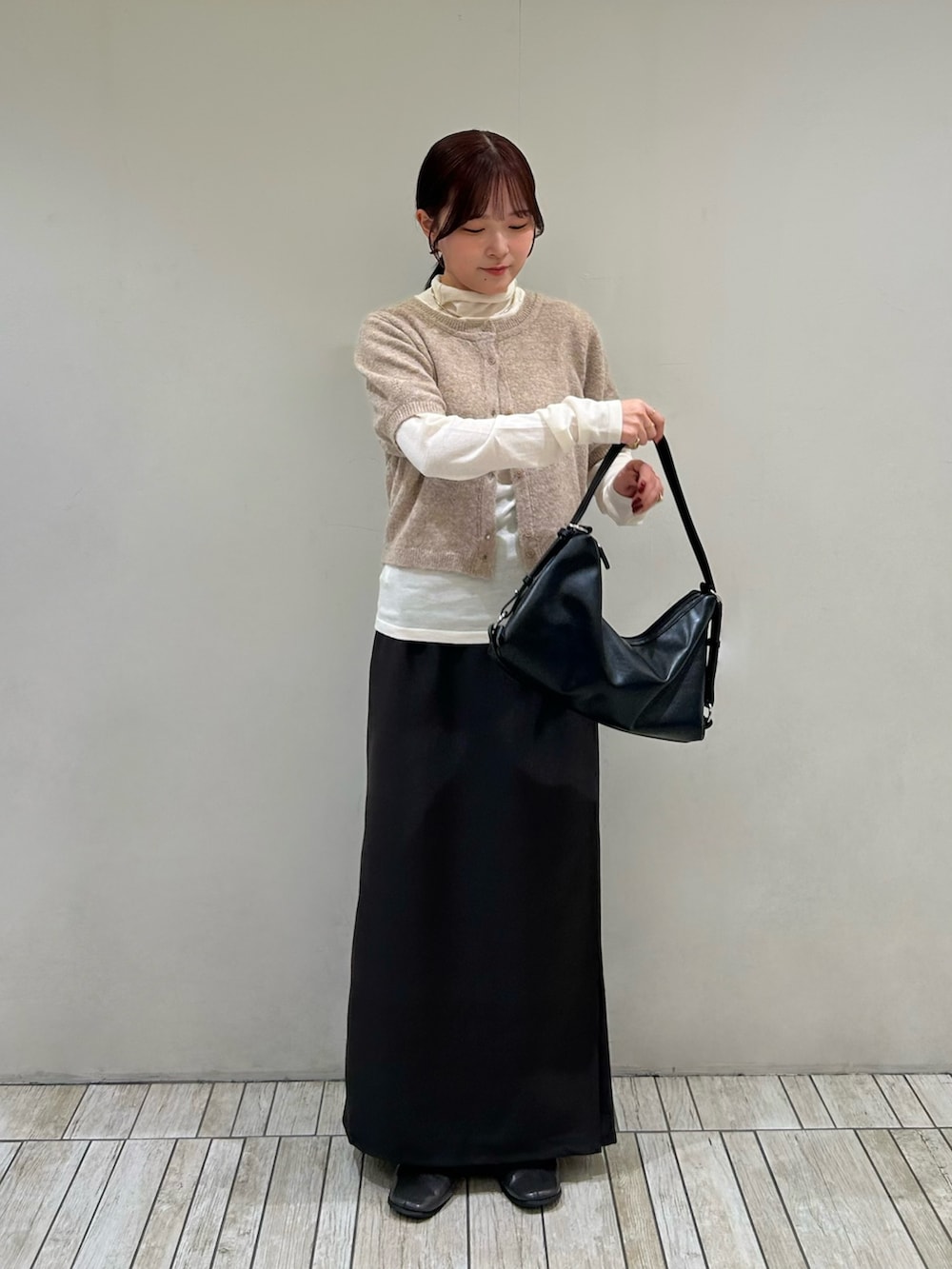 ベージュ系のカーディガン/ボレロ、ブラック系のショルダーバッグ、ブラウン系のスカートを着用したレディースの秋コーディネートの2枚目の写真