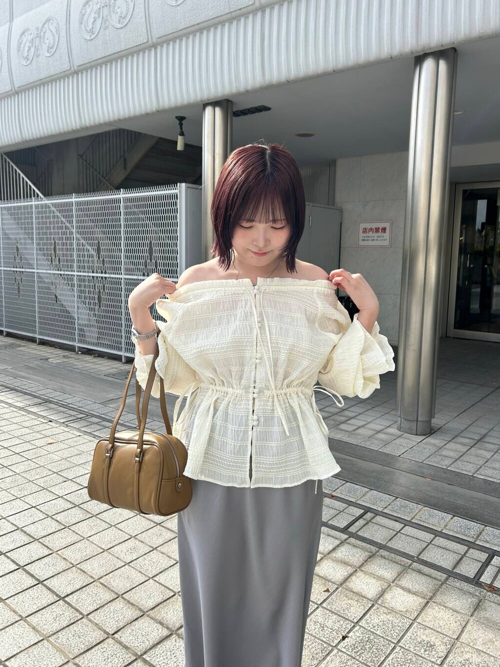 グリーン系のボストンバッグ、ホワイト系のスニーカー、ホワイト系のシャツ/ブラウスを着用したレディースの冬コーディネートの3枚目の写真