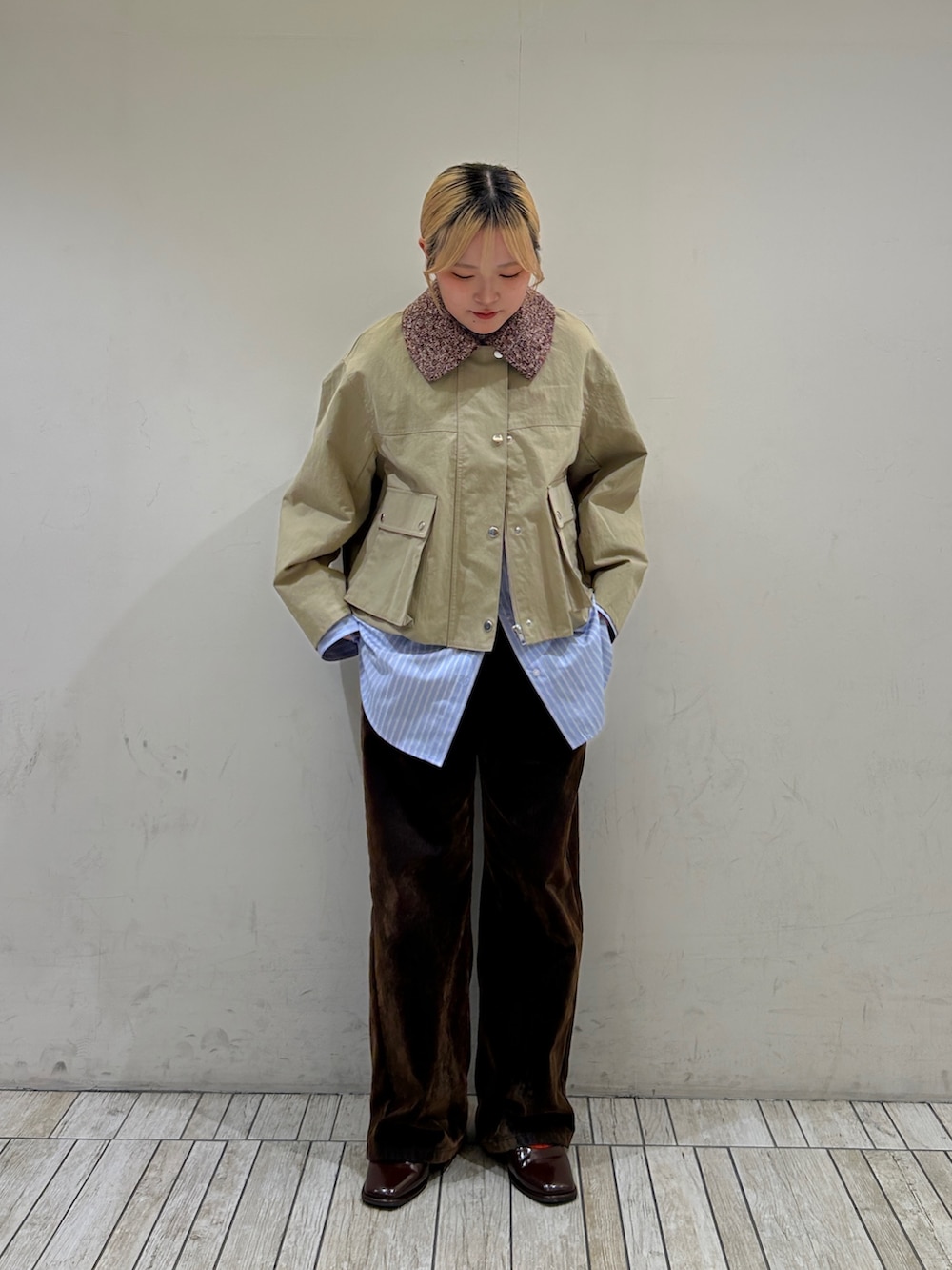 ベージュ系のブルゾン、ブルー系のシャツ/ブラウス、ブラウン系のデニムパンツを着用したレディースの冬コーディネートの2枚目の写真