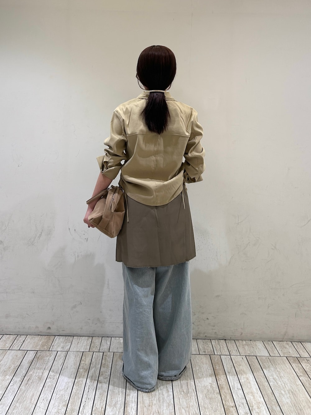 ベージュ系のシャツ/ブラウス、グレー系のスカート、ブルー系のデニムパンツを着用したレディースの夏コーディネートの3枚目の写真