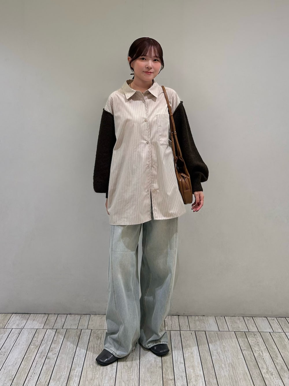 ベージュ系のシャツ/ブラウス、イエロー系のショルダーバッグ、ブルー系のデニムパンツを着用したレディースの秋コーディネートの2枚目の写真