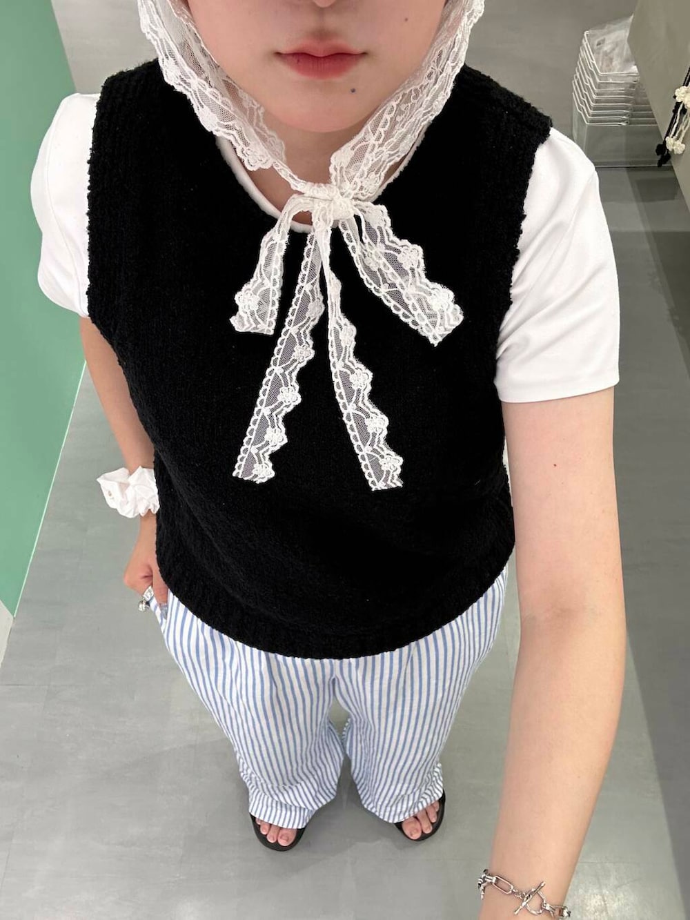 ブラック系のニット/セーター、シルバー系のブレスレット、ホワイト系のヘアゴムを着用したレディースの夏コーディネートの4枚目の写真