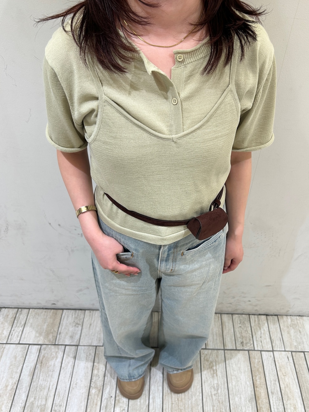ブルー系のデニムパンツ、ベージュ系のカーディガン/ボレロ、ブラウン系のベルトを着用したレディースの春コーディネートの3枚目の写真