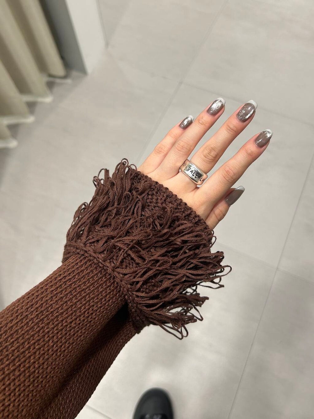 ブラック系のブーツ、ブルー系のデニムパンツ、ブラウン系のニット/セーターを着用したレディースの冬コーディネートの4枚目の写真