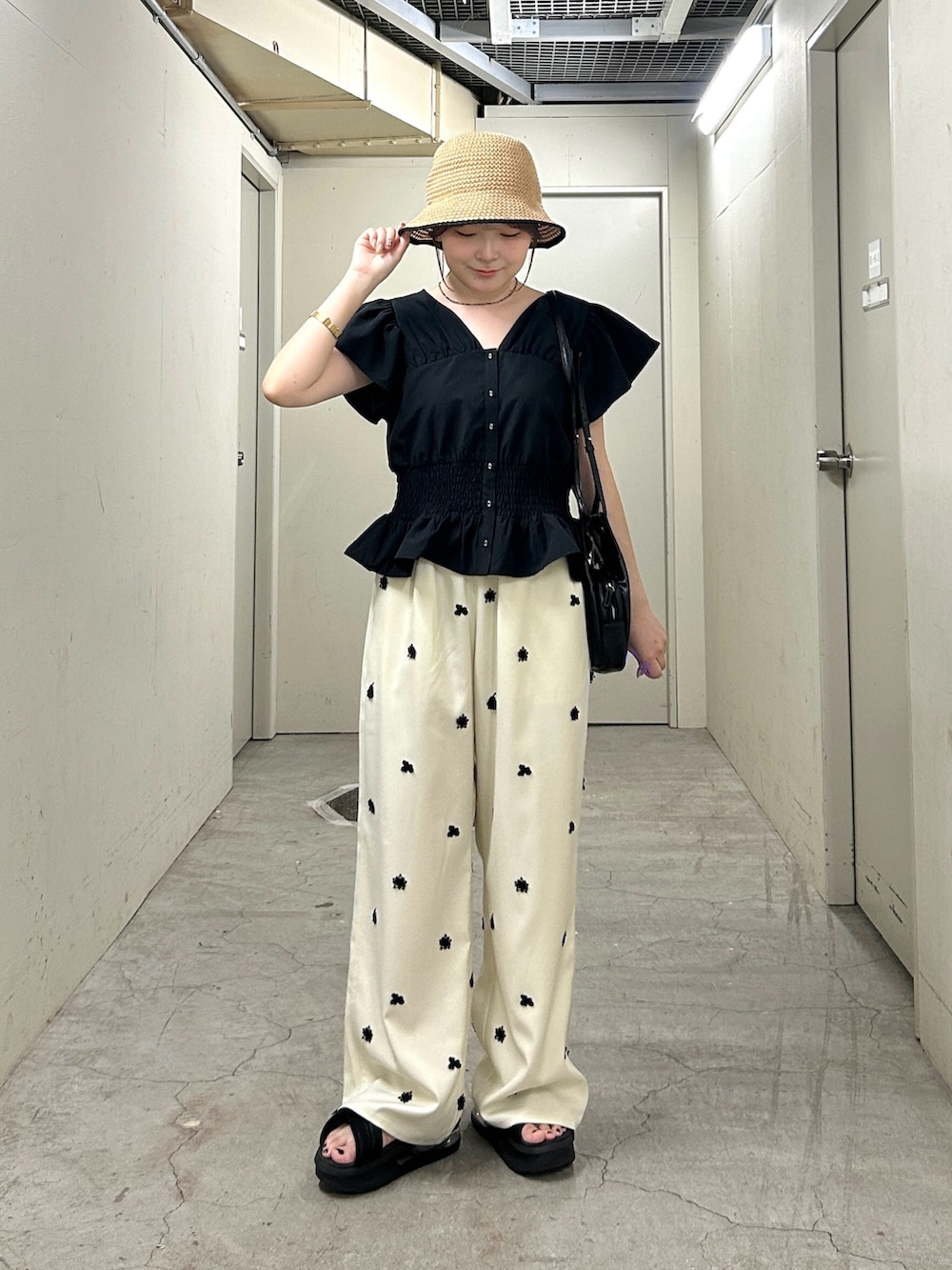 ホワイト系のその他パンツ、ブラック系のショルダーバッグ、ブラック系のシャツ/ブラウスを着用したレディースの夏コーディネートの2枚目の写真