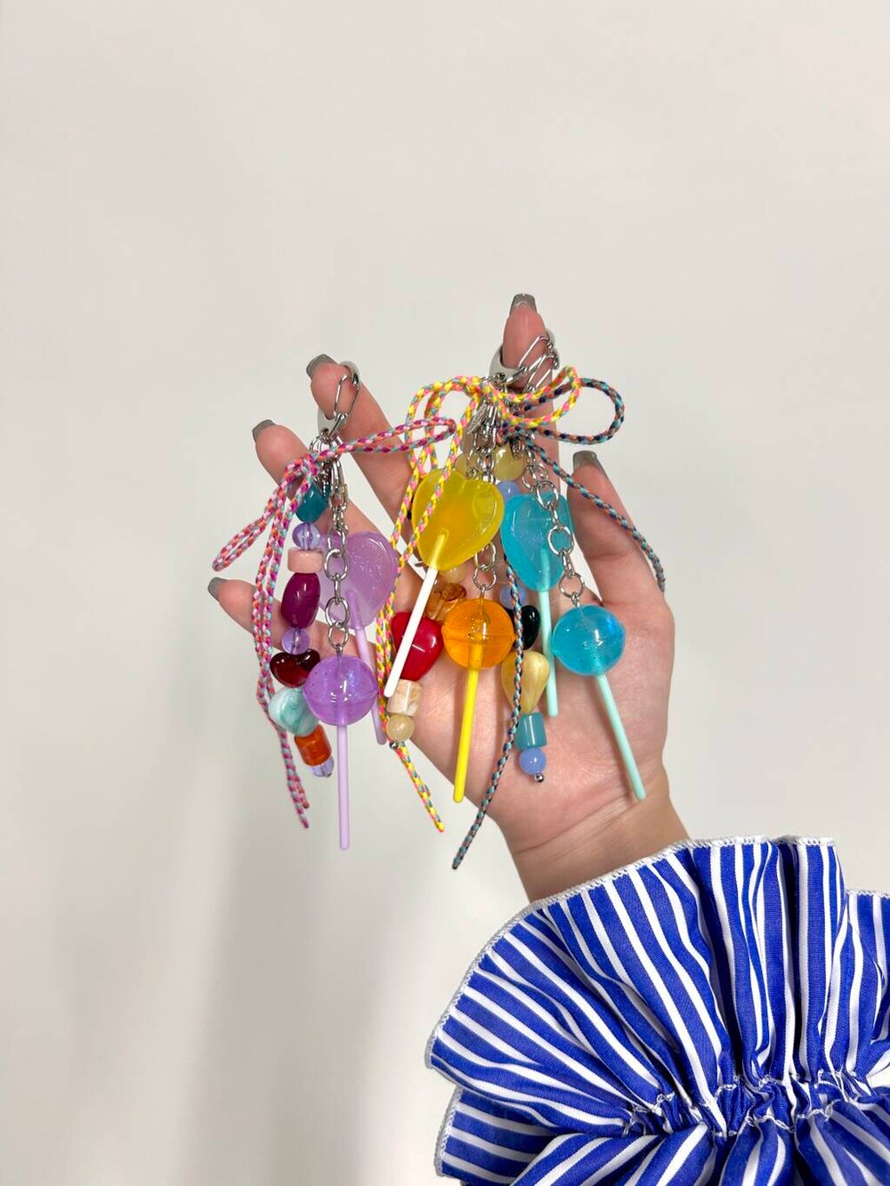 ホワイト系のショルダーバッグ、シルバー系のネックレス、シルバー系のイヤリングを着用したレディースの夏コーディネートの5枚目の写真