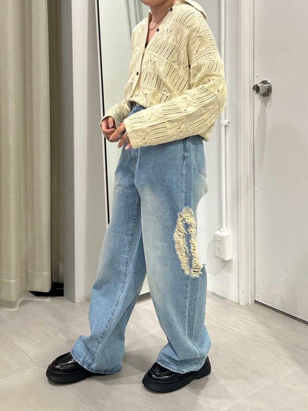 ブルー系のデニムパンツ、ブラック系のローファー、ホワイト系のカーディガン/ボレロを着用したレディースの秋コーディネートの2枚目の写真