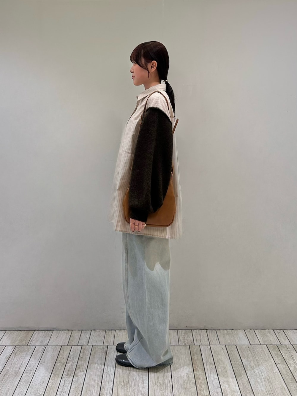 ベージュ系のシャツ/ブラウス、イエロー系のショルダーバッグ、ブルー系のデニムパンツを着用したレディースの秋コーディネートの3枚目の写真