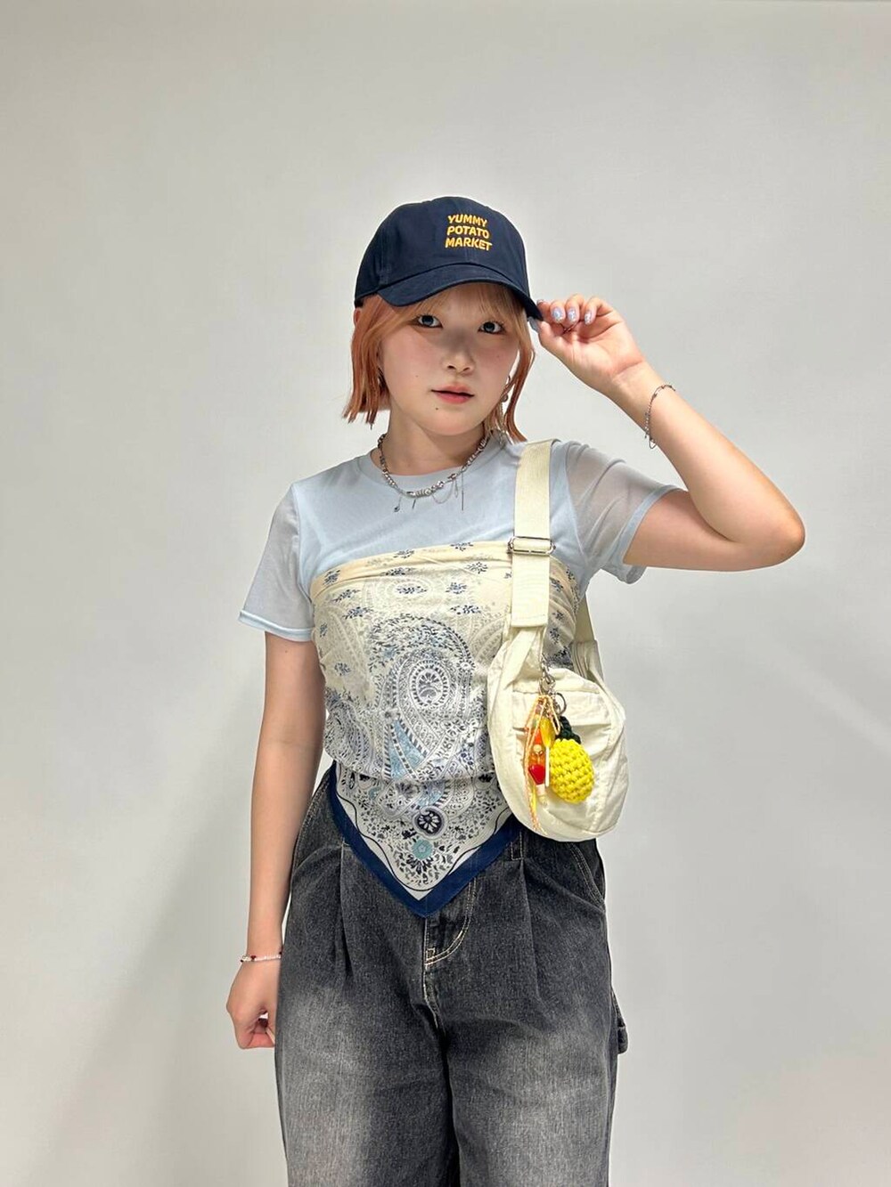 ホワイト系のショルダーバッグ、シルバー系のネックレス、シルバー系のイヤリングを着用したレディースの夏コーディネートの2枚目の写真