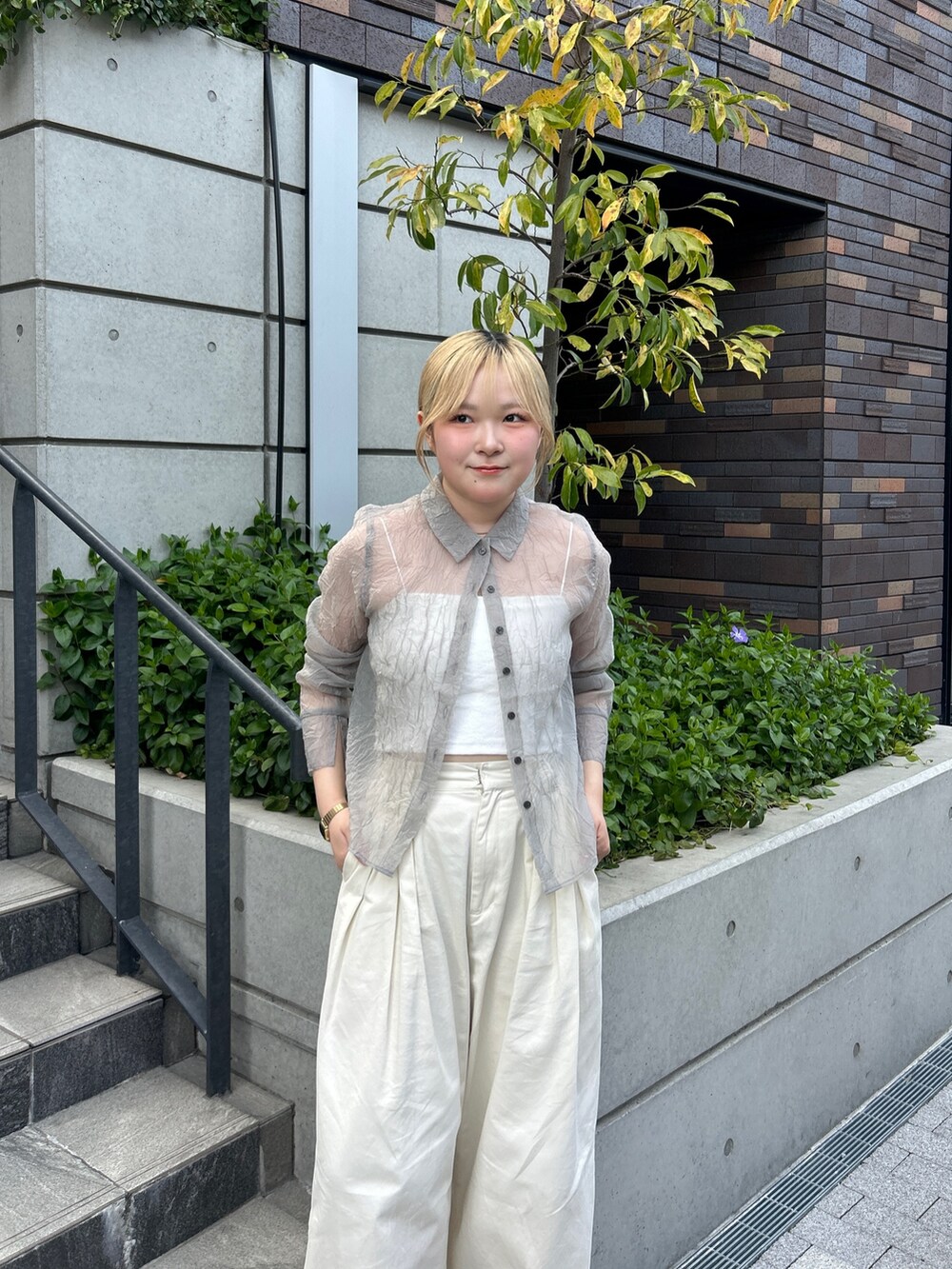 グレー系のシャツ/ブラウス、ホワイト系のその他パンツ、ブラック系のパンプスを着用したレディースの春コーディネートの5枚目の写真