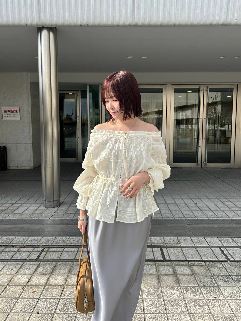 グリーン系のボストンバッグ、ホワイト系のスニーカー、ホワイト系のシャツ/ブラウスを着用したレディースの冬コーディネートの5枚目の写真