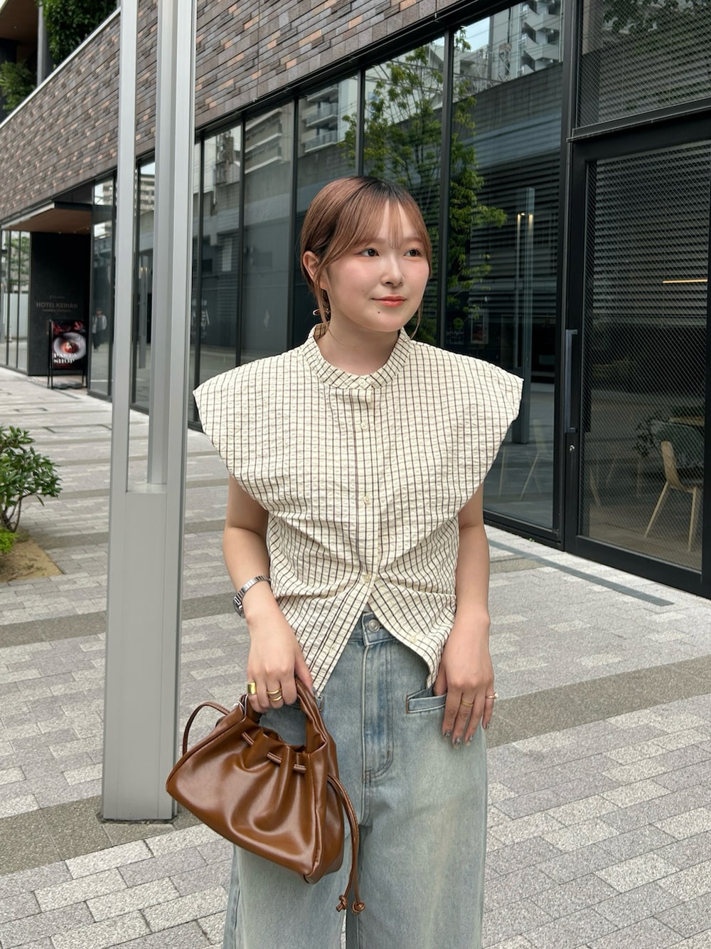 イエロー系のシャツ/ブラウス、ブルー系のデニムパンツ、ブラック系のサンダルを着用したレディースの夏コーディネートの3枚目の写真