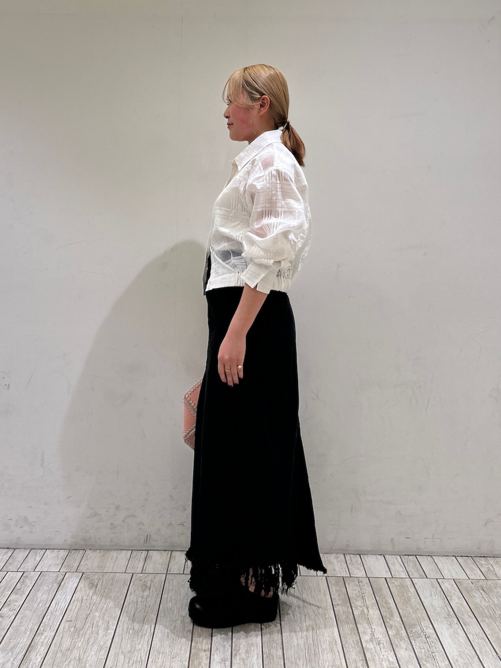 ブラック系のスカート、ブラック系のその他シューズ、ピンク系のショルダーバッグを着用したレディースの春コーディネートの3枚目の写真