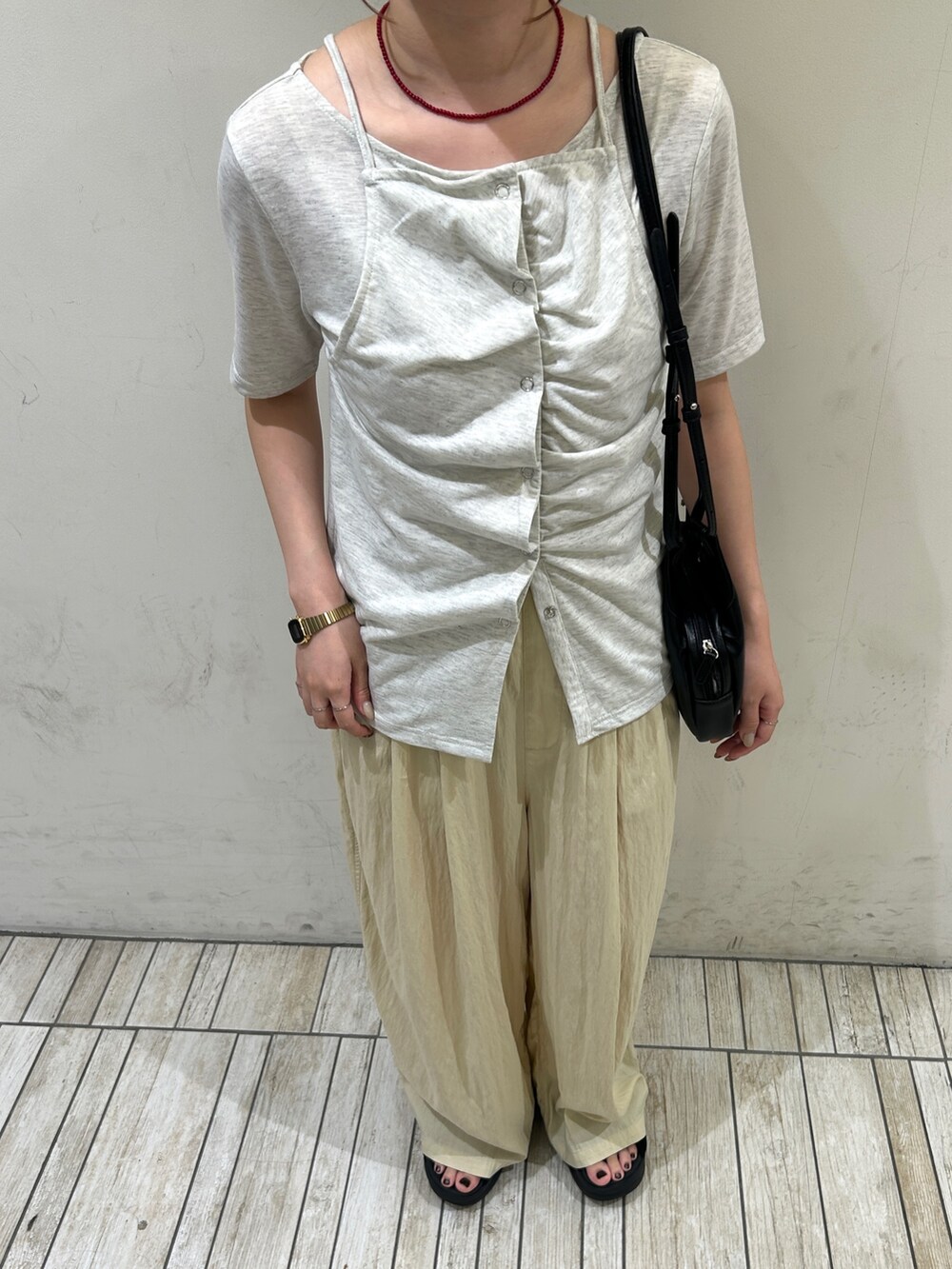 ブラック系のショルダーバッグ、イエロー系のその他パンツ、ベージュ系のTシャツ/カットソーを着用したレディースの夏コーディネートの5枚目の写真