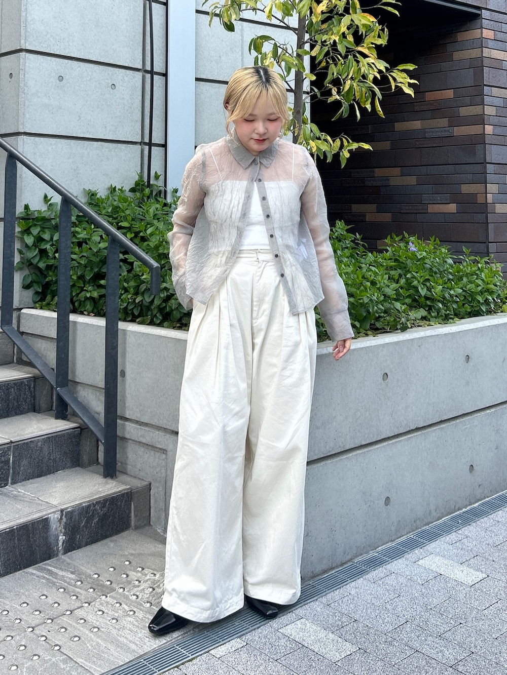 グレー系のシャツ/ブラウス、ホワイト系のその他パンツ、ブラック系のパンプスを着用したレディースの春コーディネートの2枚目の写真