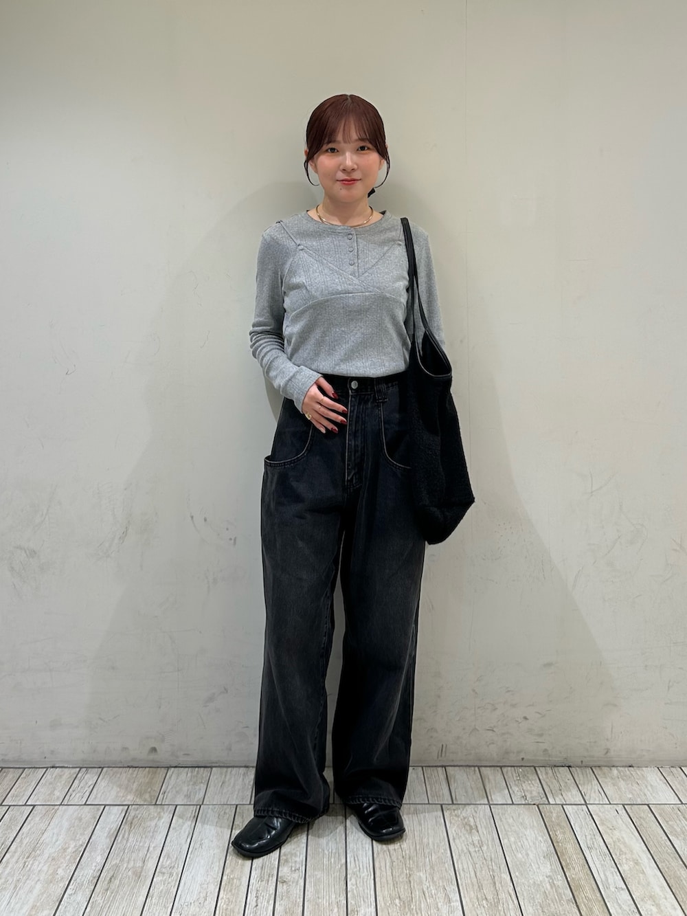 グレー系のTシャツ/カットソー、ブラック系のデニムパンツ、ブラック系のショルダーバッグを着用したレディースの秋コーディネートの2枚目の写真