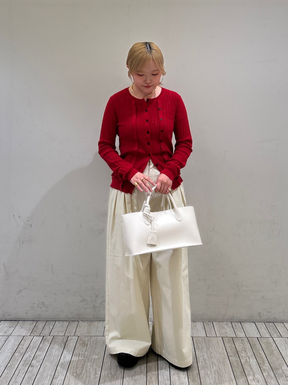 ホワイト系のその他パンツ、ホワイト系のハンドバッグ、レッド系のニット/セーターを着用したレディースの春コーディネートの2枚目の写真