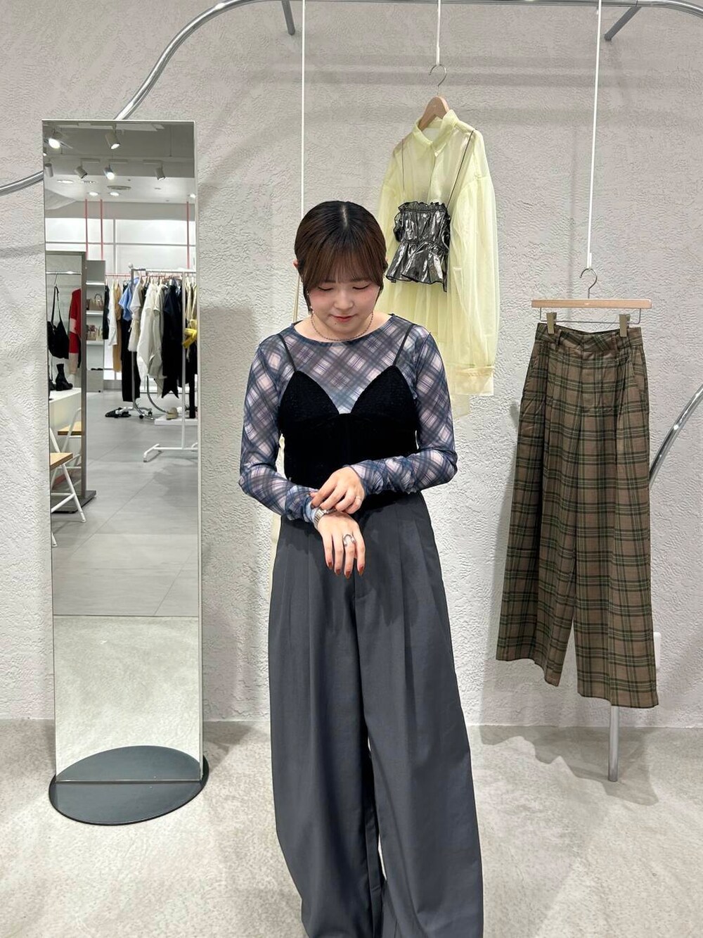 ブラック系のスニーカー、グレー系のスラックス、ブラック系のその他トップスを着用したレディースの秋コーディネートの5枚目の写真