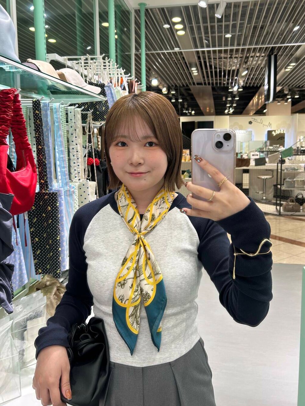 ブラック系のショルダーバッグ、イエロー系のバンダナ/スカーフ、ゴールド系のバングル/リストバンドを着用したレディースの春コーディネートの2枚目の写真