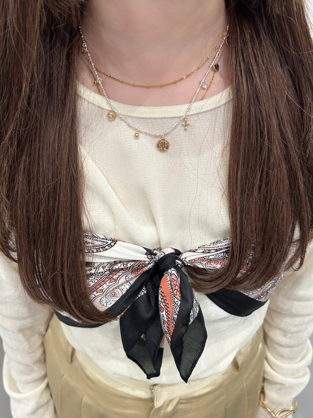 ホワイト系のTシャツ/カットソー、ベージュ系のその他パンツ、ブラック系のバンダナ/スカーフを着用したレディースの春コーディネートの4枚目の写真