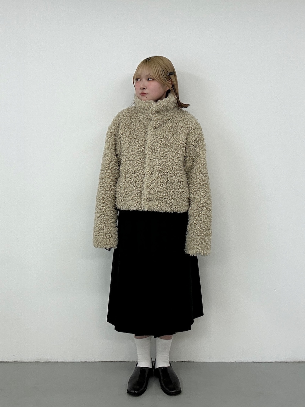 グレー系のその他シューズ、グレー系のスカート、ブルー系のカーディガン/ボレロを着用したレディースの冬コーディネートの2枚目の写真