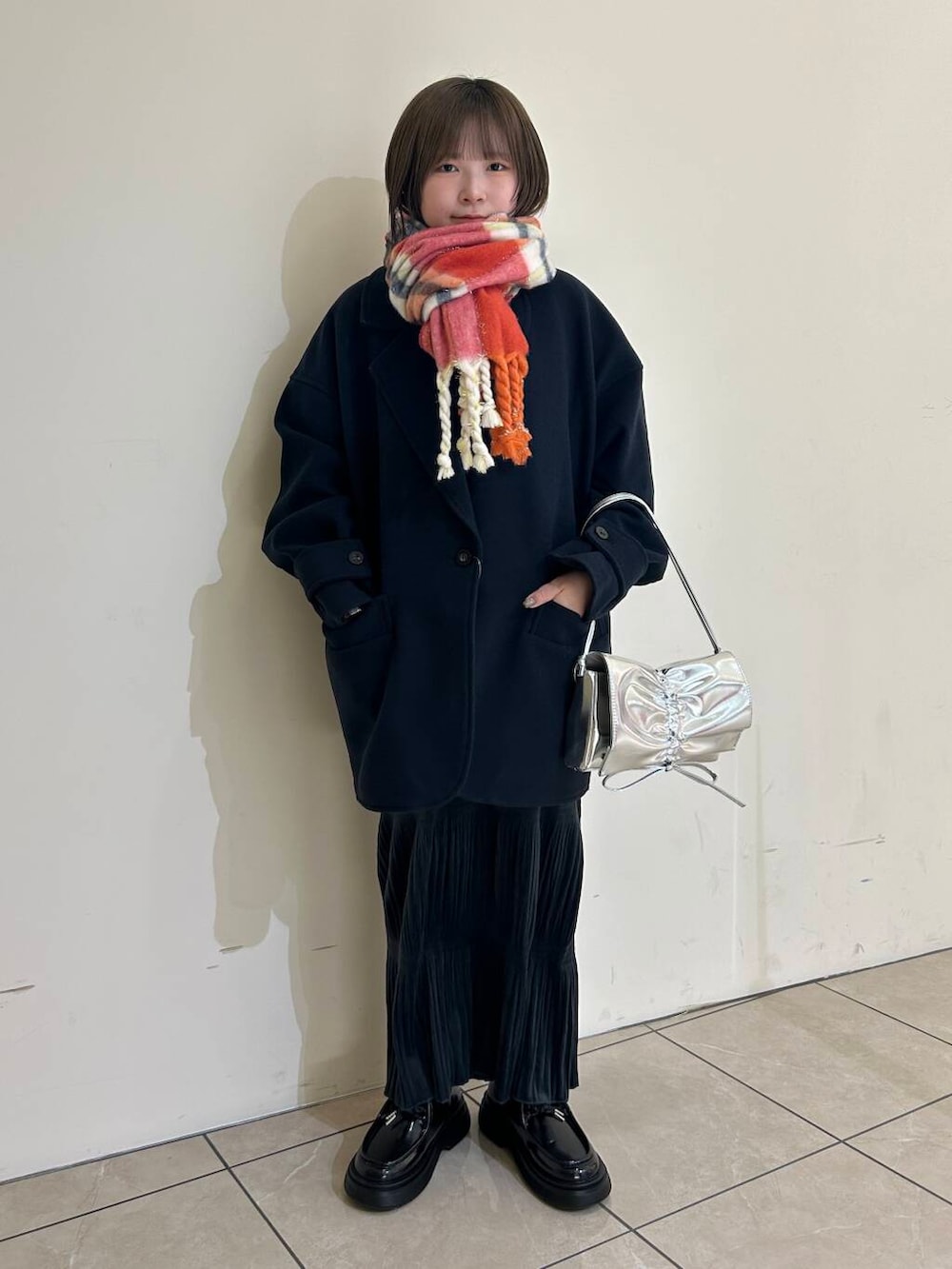 ブルー系のステンカラーコート、ブラック系のローファー、ホワイト系のシャツ/ブラウスを着用したレディースの冬コーディネートの2枚目の写真