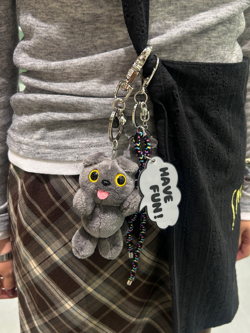 ブラック系のスニーカー、ブラウン系のスカート、ブラック系のショルダーバッグを着用したレディースの秋コーディネートの5枚目の写真