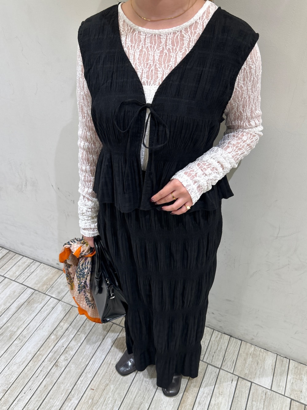 ブラック系のセットアップ、ホワイト系のTシャツ/カットソー、ブラック系のボストンバッグを着用したレディースの春コーディネートの4枚目の写真