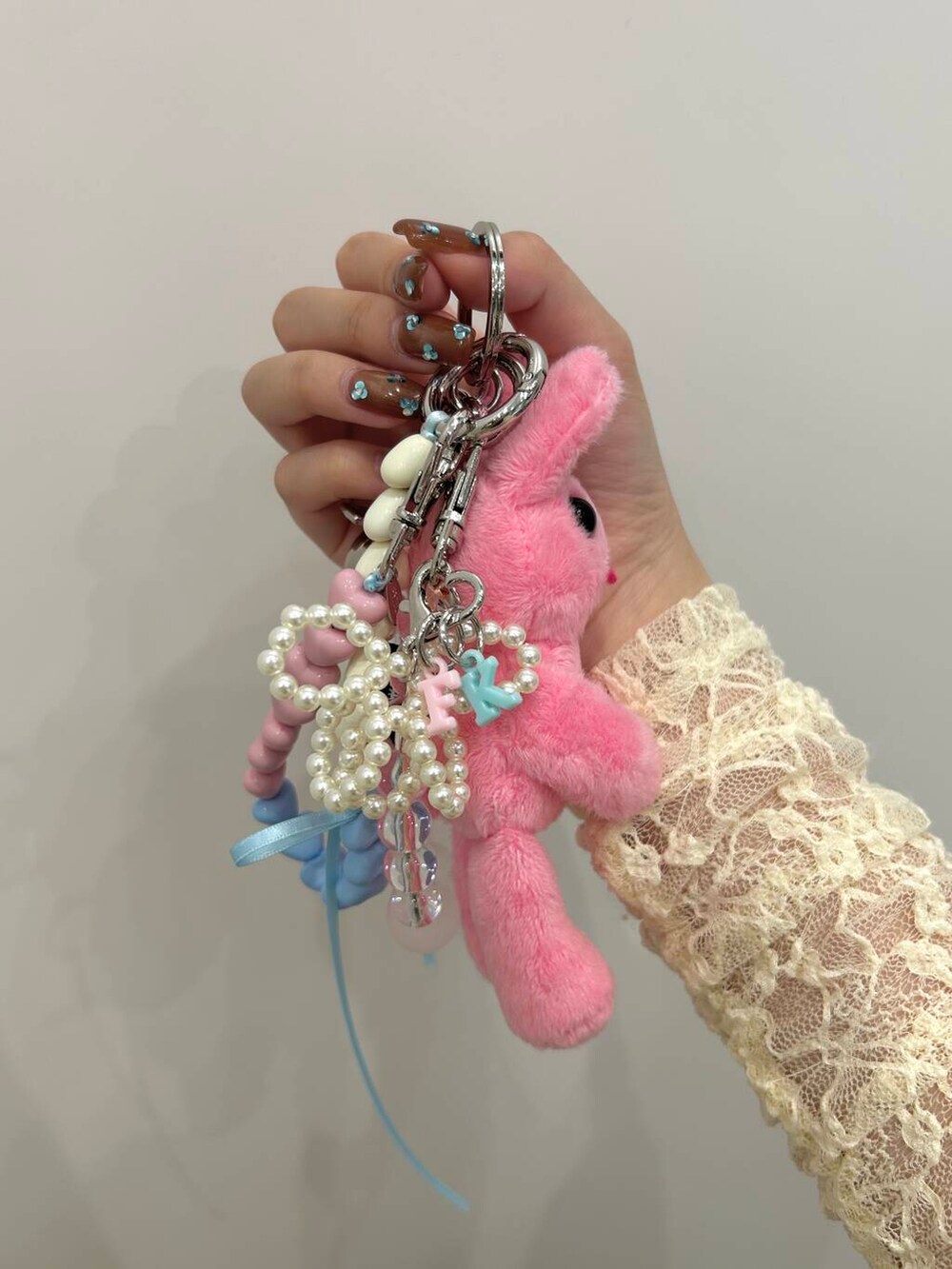 ピンク系のスマホケース/カバー、ブルー系のキーホルダー、ピンク系のキーホルダーを着用したレディースの春コーディネートの2枚目の写真