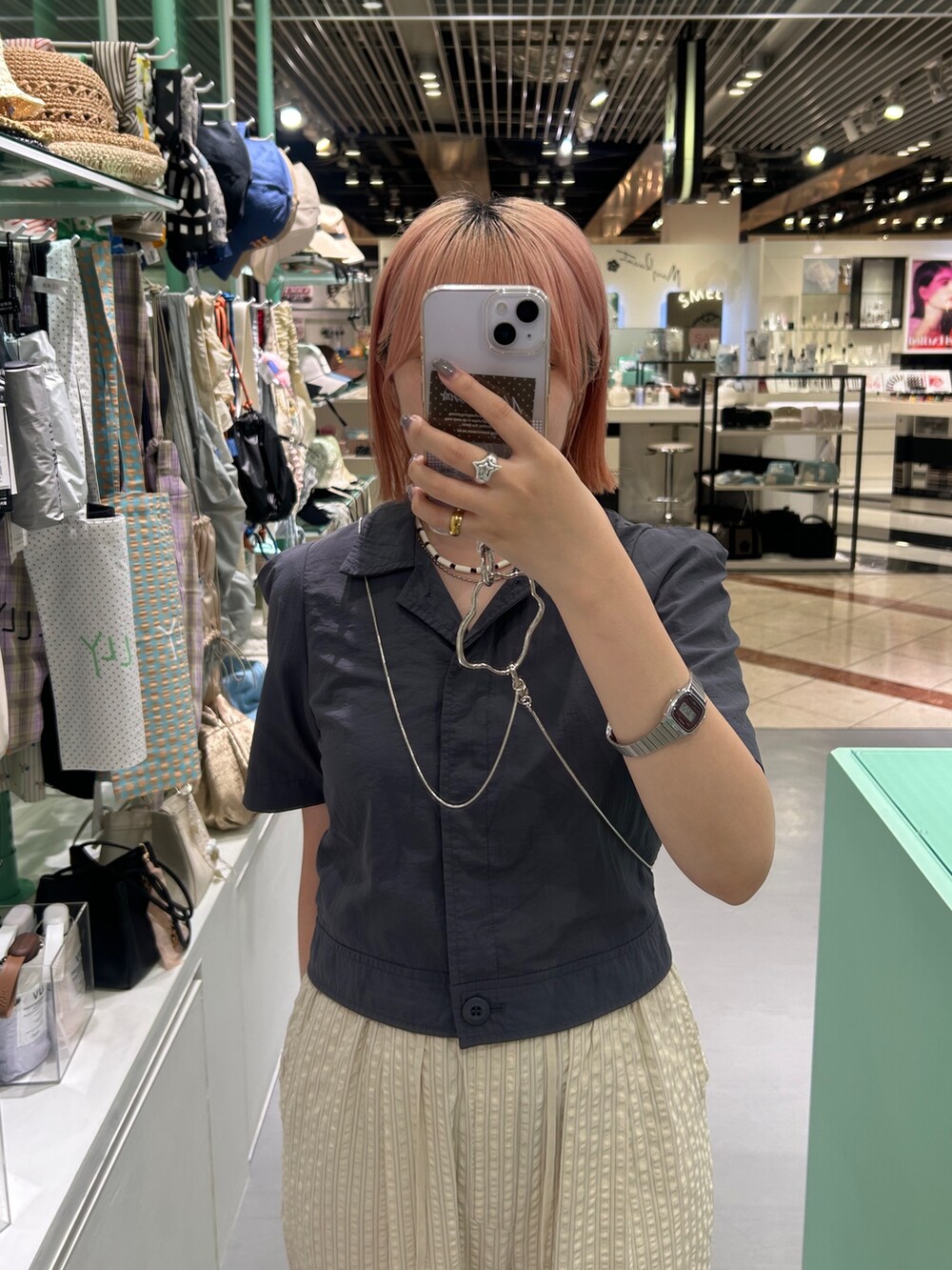 ベージュ系のその他パンツ、シルバー系のスマホグッズ、ホワイト系のネックレスを着用したレディースの夏コーディネートの2枚目の写真