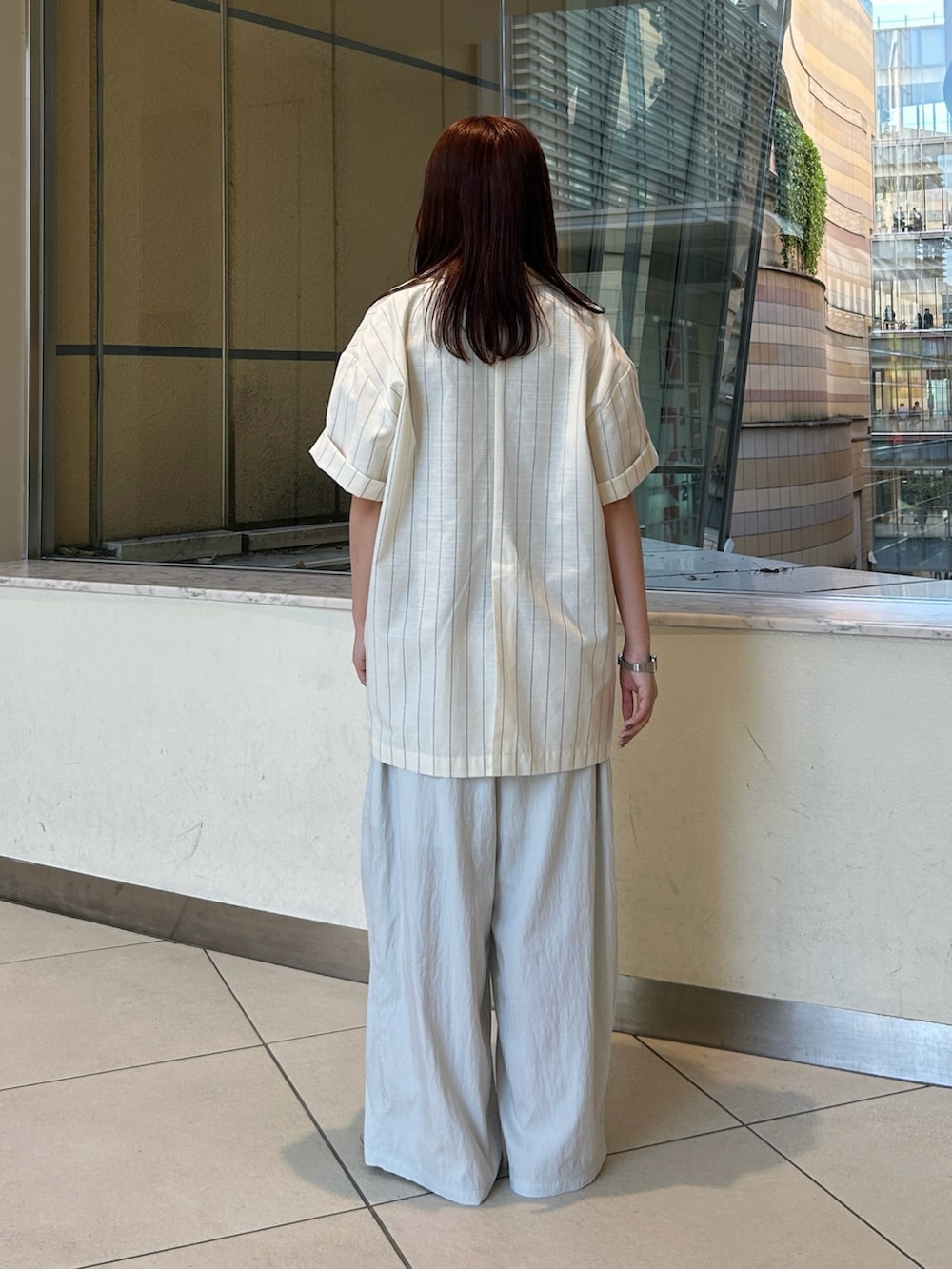 ブルー系のその他パンツ、シルバー系のサンダル、ブラック系のショルダーバッグを着用したレディースの夏コーディネートの3枚目の写真