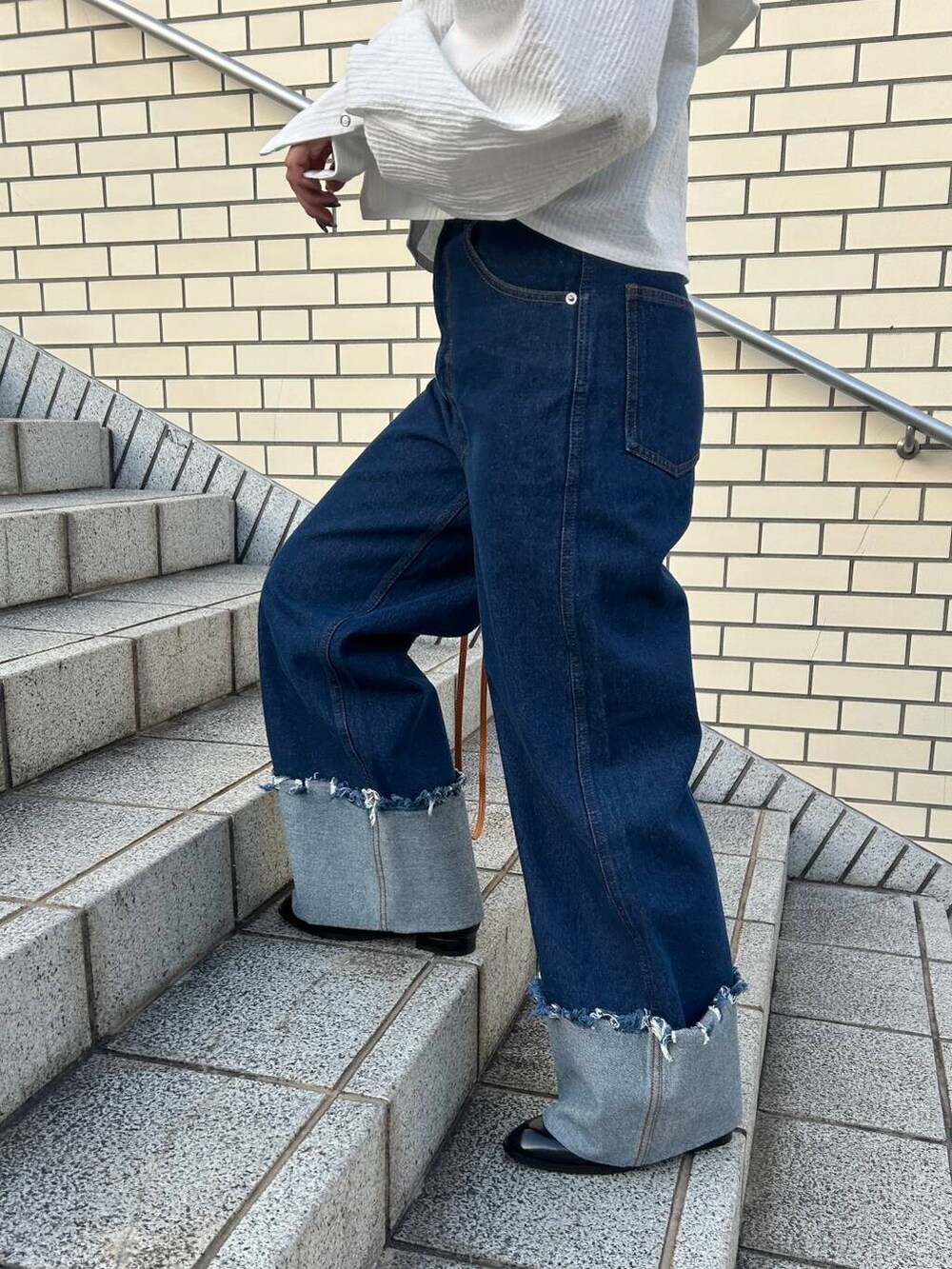 ブラウン系のキャミソール、イエロー系のハンドバッグ、ブラック系のローファーを着用したレディースの冬コーディネートの4枚目の写真