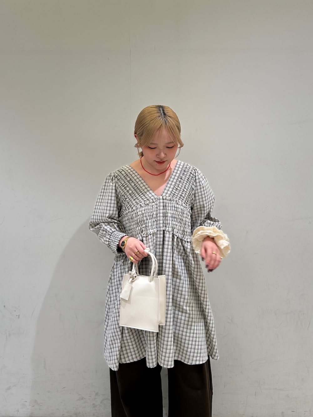 ベージュ系のワンピース、ホワイト系のハンドバッグ、ブラウン系のその他パンツを着用したレディースの春コーディネートの8枚目の写真